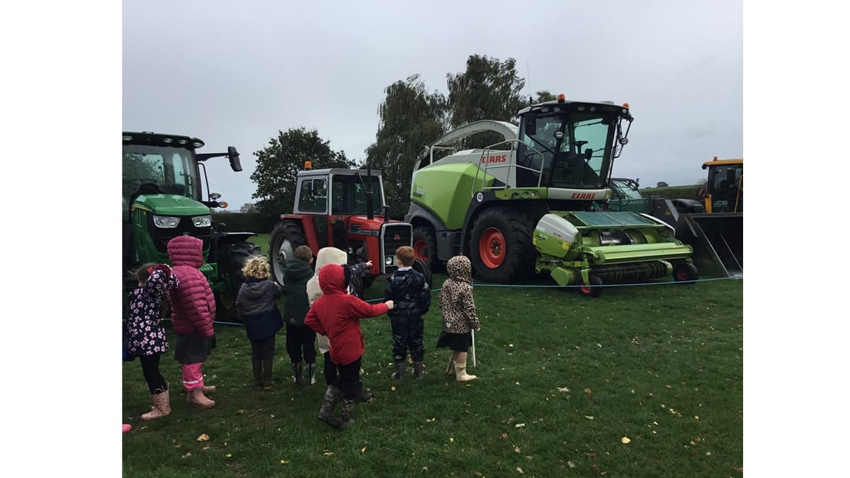 Pupils looking at tractors and a harvester during Cooper Perry Primary School’s harvest celebration